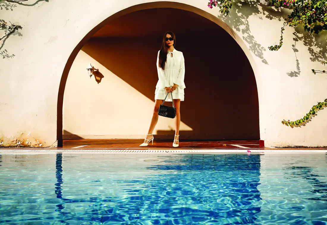 Conceptual image: a swimming pool beside a shaded stucco arch