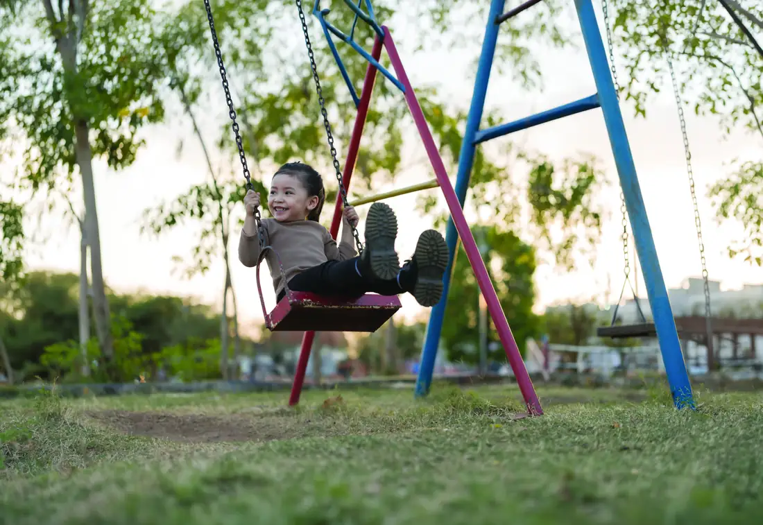 Conceptual image: a child on a swing in a park